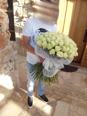 Man with a bouquet of 101 white roses